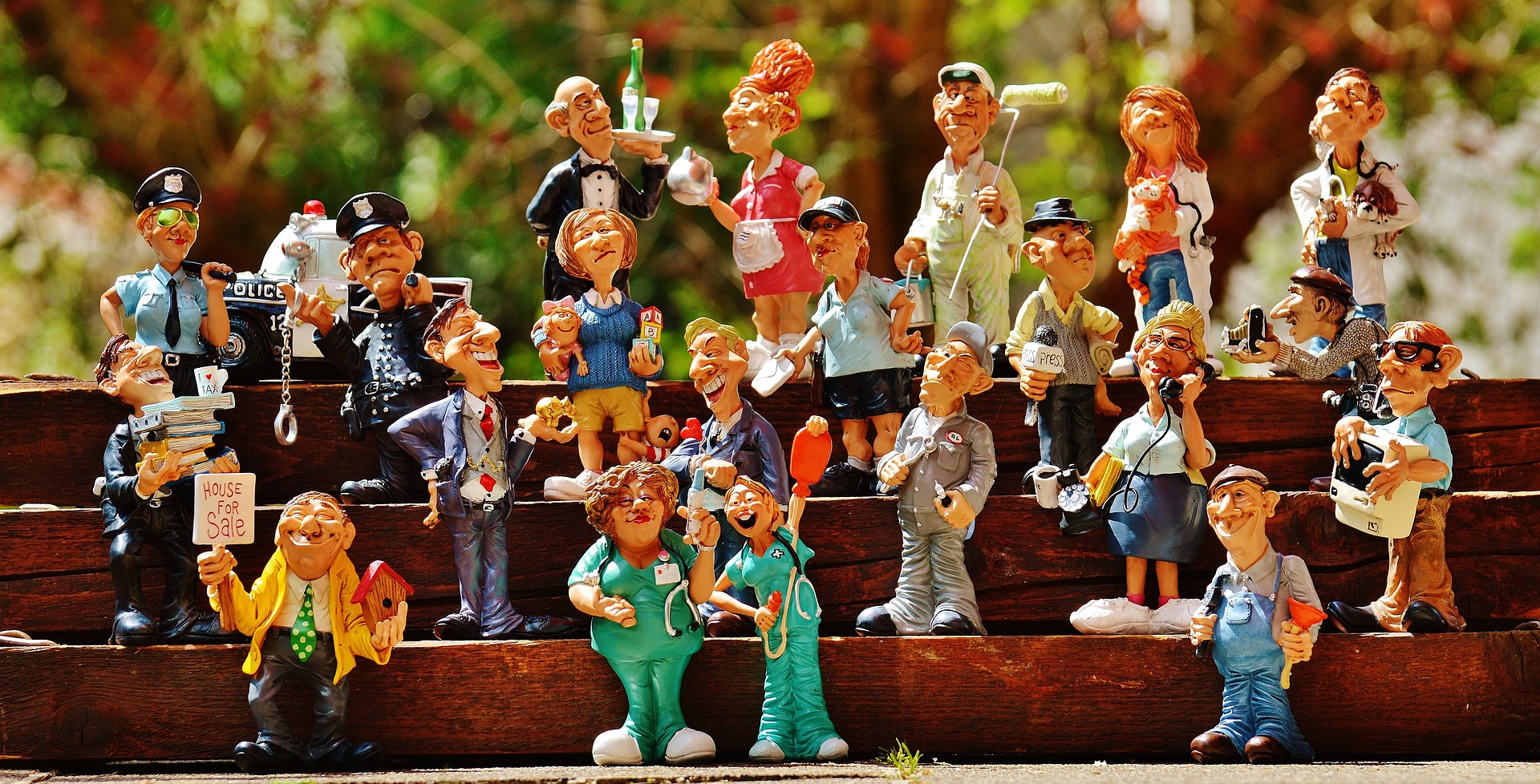 Little plastic figures depicting various jobs standing on some steps.